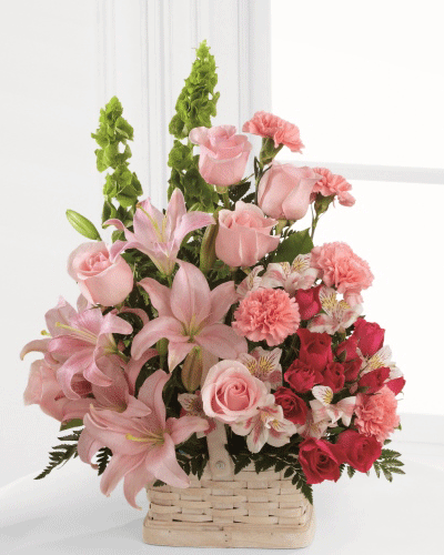 Beautiful Spirit Arrangement with pink roses lilies carnations spray roses and Bells of Ireland in white basket Toronto delivery