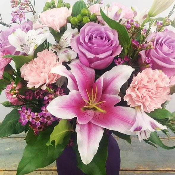 Delightful Surprise Bouquet – Lavender roses and pink oriental lilies in a glass vase.