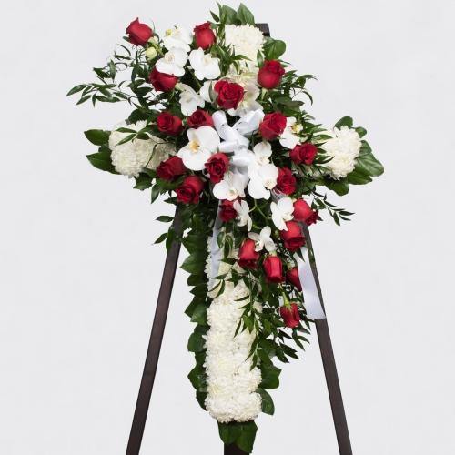 Always Loved Funeral Cross with white mums red roses white orchids greenery satin ribbon.