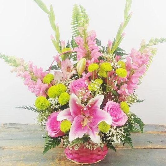 Blushes of Pink Basket with pink lilies roses snapdragons gladiolus green poms baby’s breath.