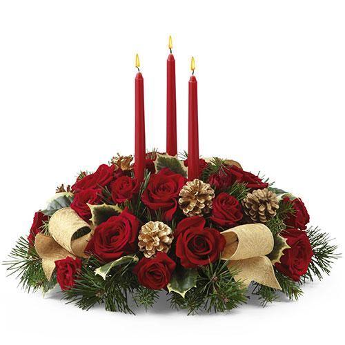 Holiday centerpiece with red roses, red spray roses, holly, gold pinecones, ribbon, and three red taper candles