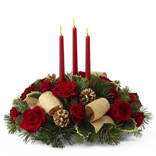 Holiday centerpiece with red roses, red spray roses, holly, gold pinecones, ribbon, and three red taper candles