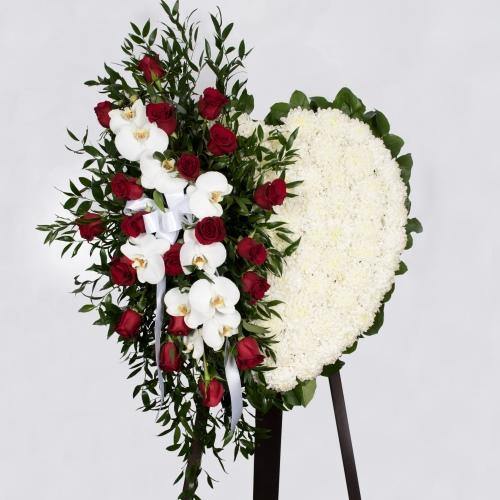 Heart shaped funeral wreath with red roses and white orchids.
