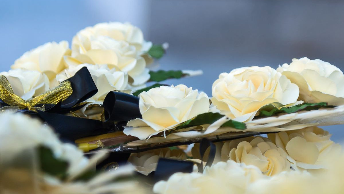 White roses with black ribbon funeral arrangment.