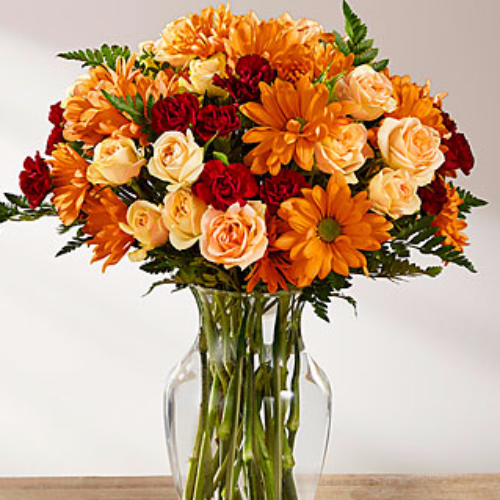 Golden Autumn Bouquet with peach spray roses, burgundy carnations, butterscotch chrysanthemums & lush greens in clear glass vase