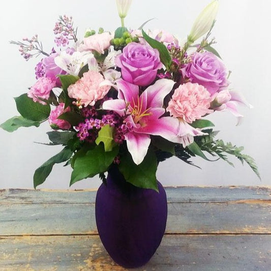 Delightful Surprise Bouquet – Lavender roses and pink oriental lilies in a glass vase.