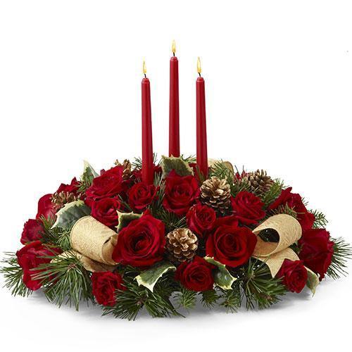 Holiday centerpiece with red roses, red spray roses, holly, gold pinecones, ribbon, and three red taper candles
