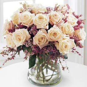 A bouquet of 18 roses in pink, red, yellow, white, or peach, accented with pink waxflower and heather.